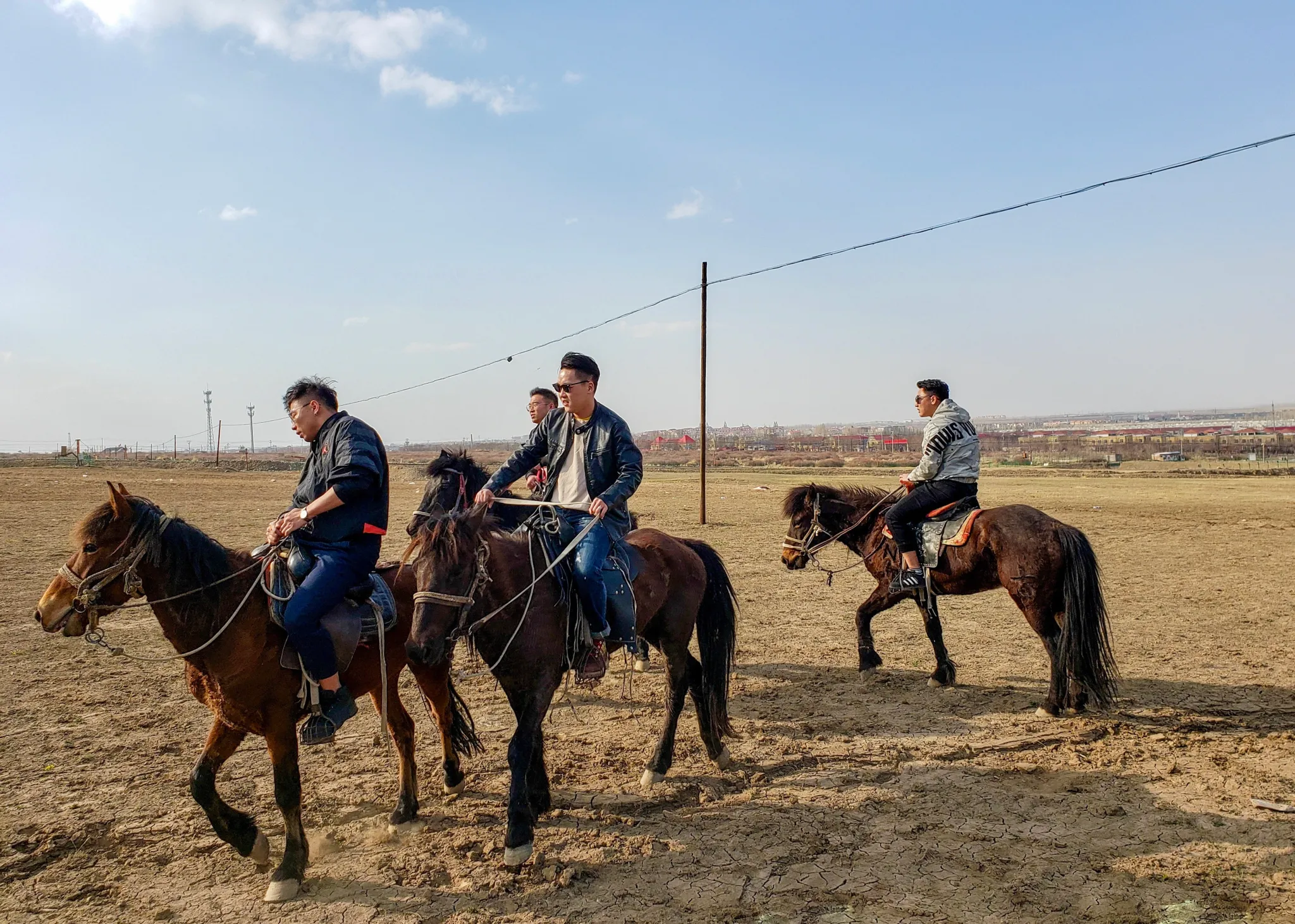 A group riding horses across an open field