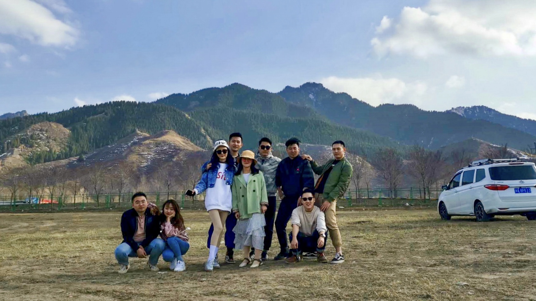 A group portrait in front of a mountain landscape